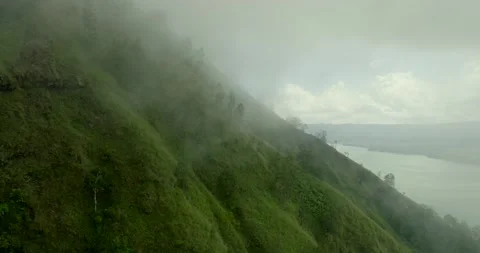 Green mountain with trees under cloudy sky seen from above Видео 274151087