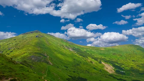 Green mountain under blue cloudy sky, travel time lapse scene Stock Footage 166576603