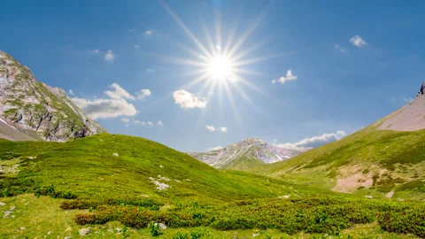 Green mountain valley under a sparkle sun time lapse scene Stock Footage 289622043