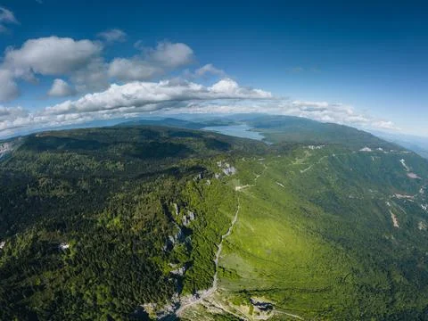 Green mountains covered with thick at golden hour, cumulus clouds, aerial vie Stock Photos