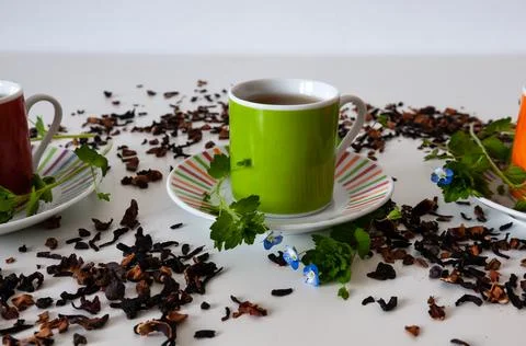 Green mug on a white table with leafs and flowers and white background Stock Photos