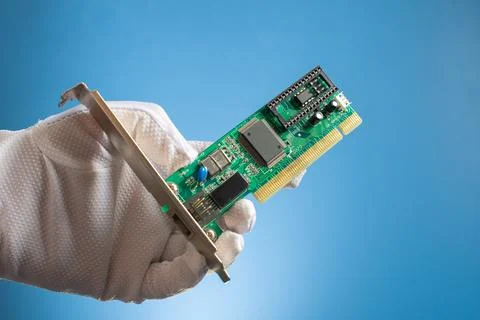 Green network board with microchips and transistors in hand on a blue backgro Stock Photos
