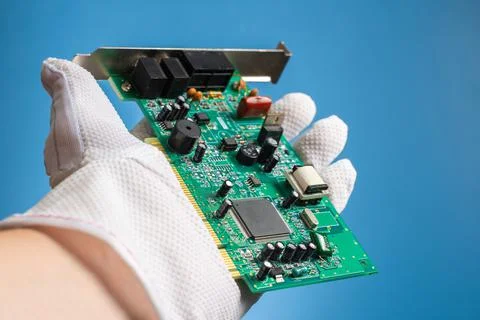 Green network board with microchips and transistors in hand on a blue backgro Foto stock