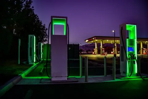 Green night lights of electric car charging station Stock Photos