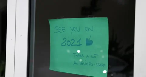Green note on a door see you in 2021 closed because of covid 19 pandemic Stock Footage 150156482
