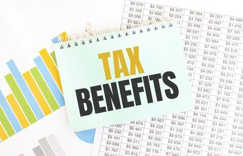 Green notepad on financial documentation. Text TAX BENEFITS. Business concept Stock Photos