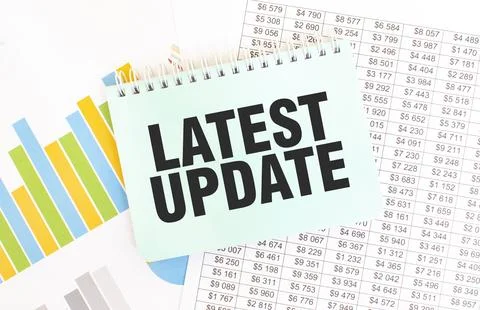 Green notepad on financial documentation. Text LATEST UPDATE. Business concep Stock Photos