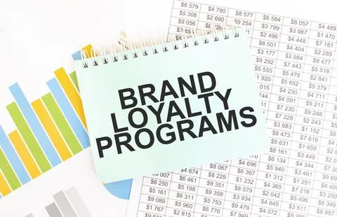 Green notepad on financial documentation. Text BRAND LOYALTY PROGRAMS. Busi.. Stock Photos