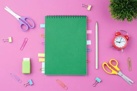 Green notepad with stationery on a pink background Foto stock