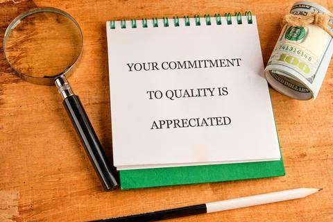 A green notepad with the text Your commitment to quality is appreciated lies  Foto stock