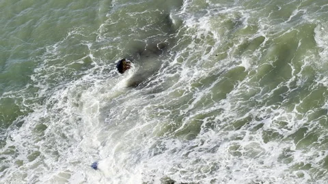 Green ocean waves crashing over rocks aerial Stock Footage 336521594