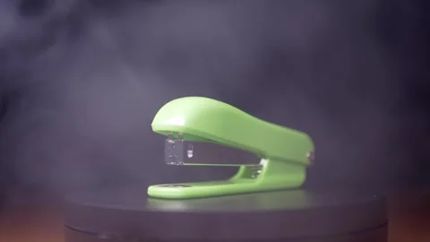 Green Office Stapler Rotating In White Smoke On Black Background Stock Footage 330113403