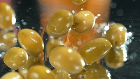 Green olives fall on the table under water splashes in slow motion , 4k, phantom Stock Footage 114977986