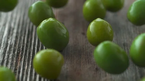 Green olives falling and rolling on a table. Slow Motion. Stock Footage 84930914