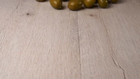 Green olives falling and rolling on a table. Slow Motion. Video stock 124131789