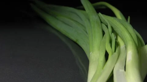 Green onion close-up. Black background. A fresh vegetable. Видео 144352693