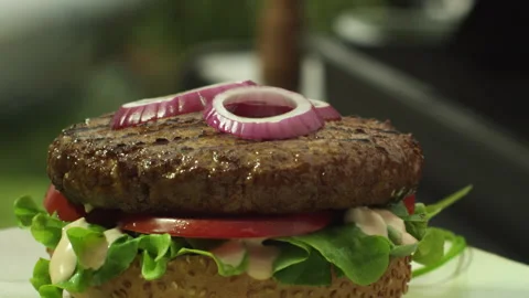 Green onion falling on burger Stock Footage