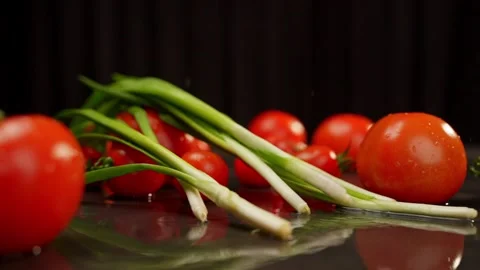 Green onions fall effectively on beautifully arranged tomatoes of various sizes. Stock Footage 270736770