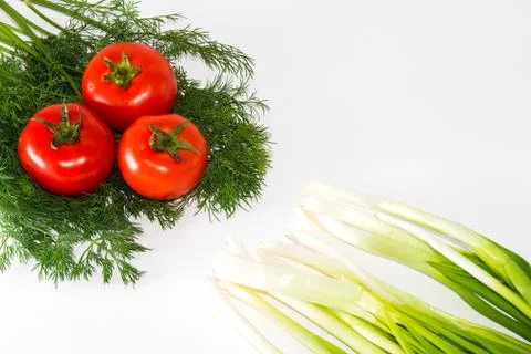 Green onions, tomatoes and dill lying on a white background Stock Photos