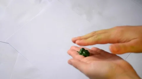 Green paint smeared hands through white paper Stock Footage 69827805