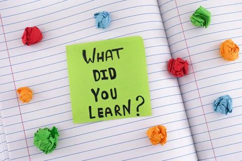 A green paper note with the question What did you learn on it on a notebook s Stock Photos