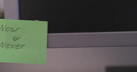 A green paper notes with the reminder Now or Never on it sticked on to a monitor Stock Footage 254557465