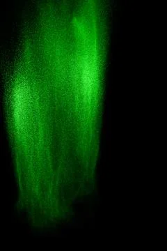 Green particles explosion on black background. Color dust splash. Stock Photos