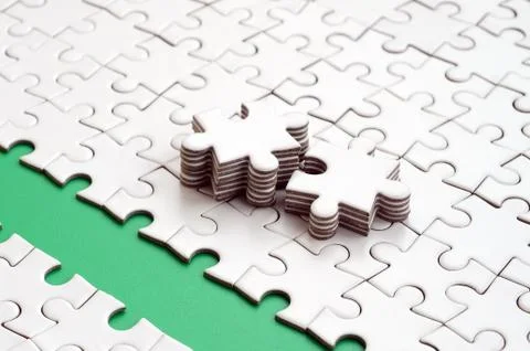 The green path is laid on the platform of a white folded jigsaw puzzle. The m Stock Photos