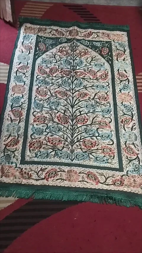 The green patterned prayer mat is very nice Stock Footage 293056455