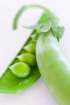 Green pea pod  on a white table Stock Photos