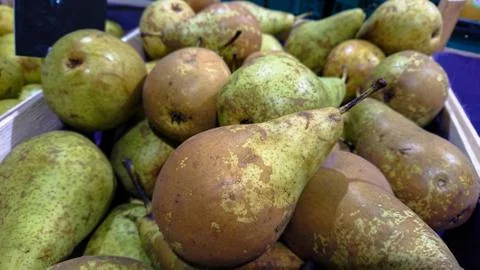 Green pears in the box on the counter Stock Photos