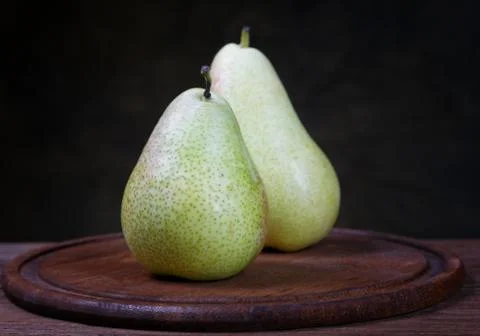 Green pears on an old kitchen table closeup Stock Photos