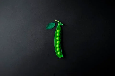 Green peas on a black background. Stock Photos