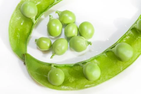 Green peas, close-up on a white background, plate Stock Photos