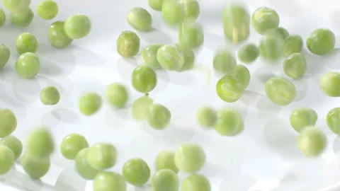 Green Peas Falling on a Plate Stock Footage 327407832