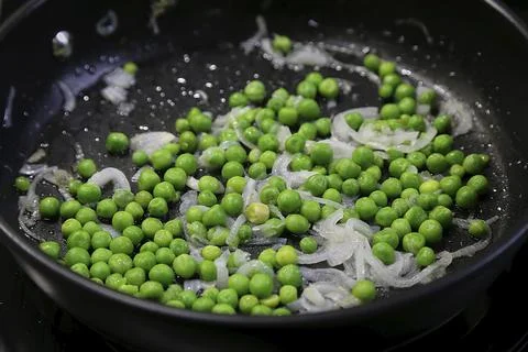 Green peas in the kitchen in a pan. Stock Photos