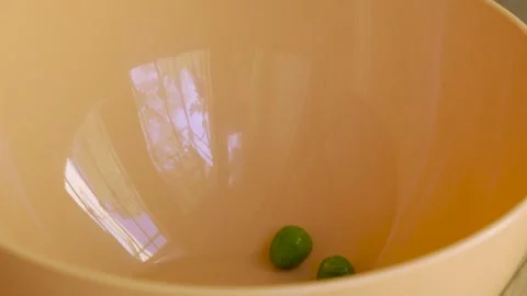 Green peas macro falling into pale orange bowl 10bit 120fps Видео 333693593