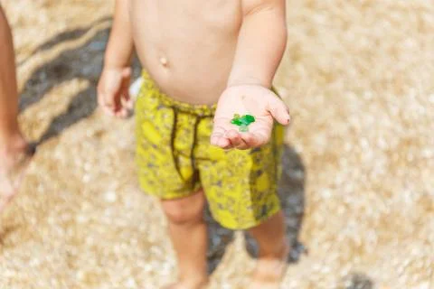 Green pebbles in a small palm 스톡 사진