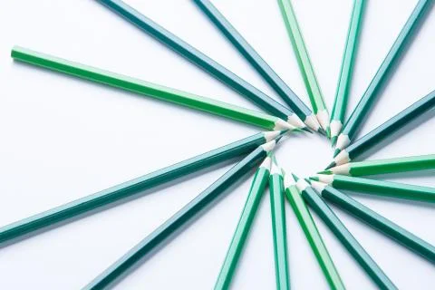 Green pencils arranged in a circle on thr right side on light background, top Stock Photos