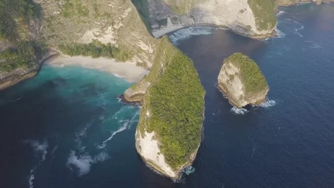 Green peninsula surrounded by the beautiful turquoise ocean waves aerial footage Stock Footage 101670004