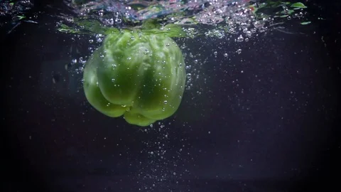 Green pepper falls into the water. Video stock 122979634