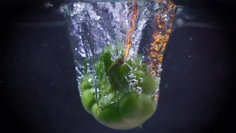 Green pepper falls into the water. Stock Footage 122979728
