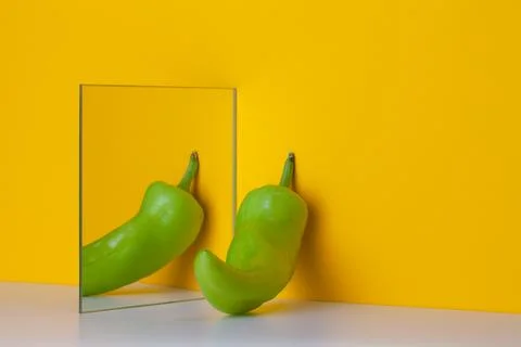 Green pepper is reflected in a mirror on a yellow background Stock Illustration