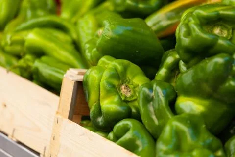 Green pepper in a wood basket at market Stock Photos