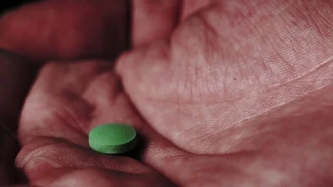 Green pill falling in an open palm. Stock Footage 82877694