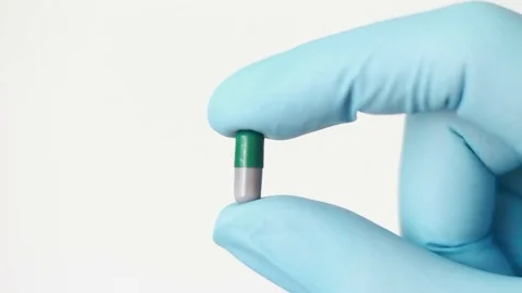 Green pill in hand dressed in rubber glove Vídeo Stock 79589949