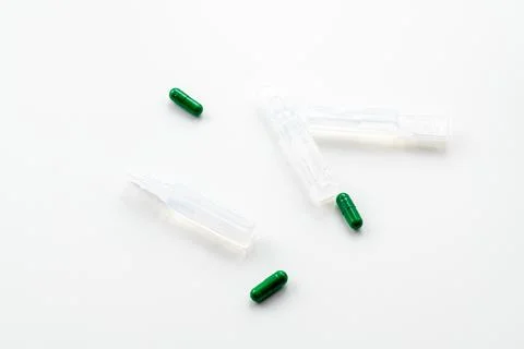 Green pills and ampoules on the table. Foto stock