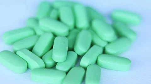 Green pills on the table, partially out of focus. Calcium Stock Footage 170014438