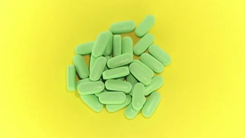 Green pills on a yellow background Stock Footage 170022546