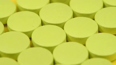 Green pills on yellow background. Side view. Extrem close-up. Loop motion. Stock Footage 167061607